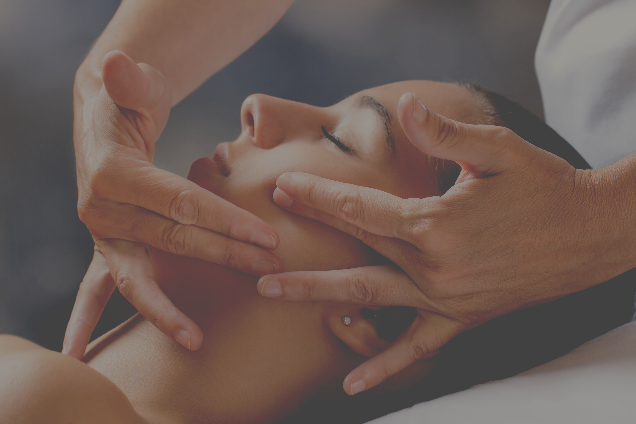 Therapist massaging female face.