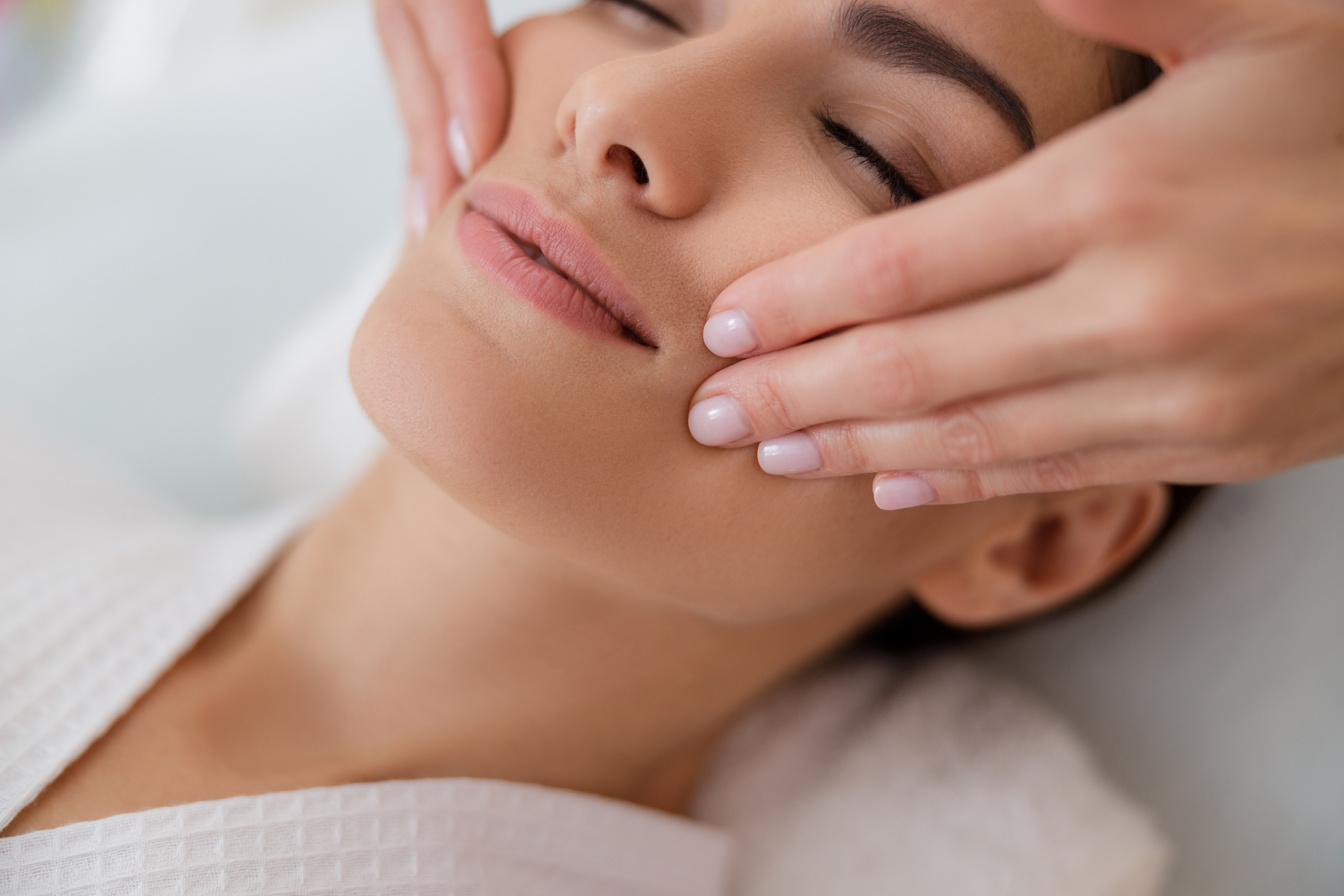 Young lady having face massage at spa salon